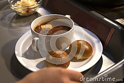 man puts borsch with donuts on his tray Stock Photo