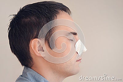 Man puts on and removes a strip for the nose from black dots. Coal cleaning strips from blackheads and comedones. concept of Stock Photo