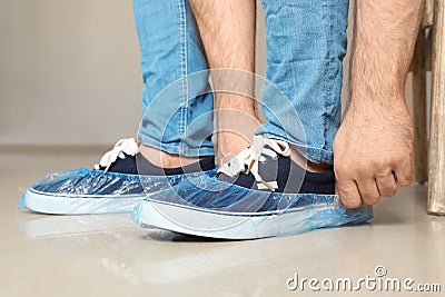 Man putting on blue shoe covers Stock Photo