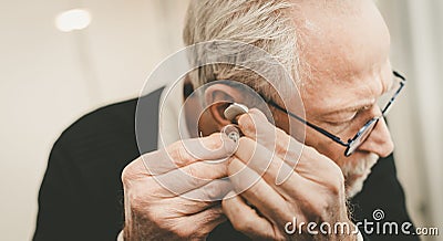 Man putting hearing aids Stock Photo