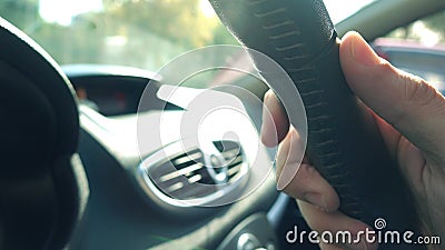 Man putting his hand on leather steering wheel against blazing sun Stock Photo
