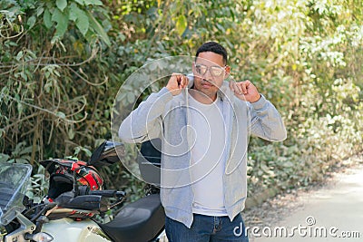 Man putting on a jacket to ride a motorcycle Stock Photo
