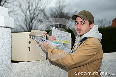 Man putting newspaper from the mailbox Stock Photo