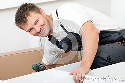Man putting together self assembly furniture Stock Photo