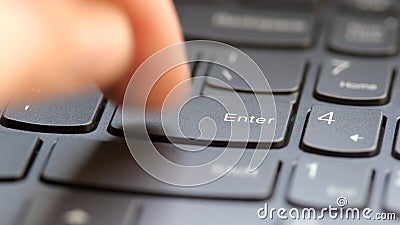Man quickly pressing the enter key on a modern laptop computer keyboard, macro detail extreme closeup, shallow DOF, one person. Stock Photo