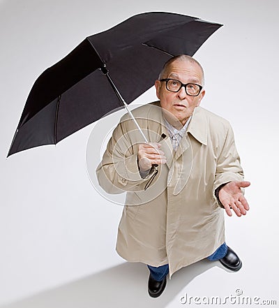 Man in raincoat holding umbrella checking for rain Stock Photo