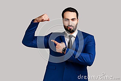 Man raising hands showing power, pointing at his biceps, feeling independent strong with proud look. Stock Photo