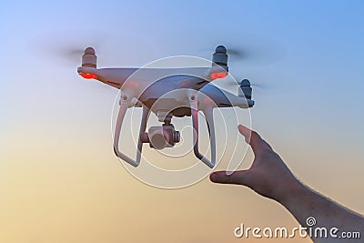 Man reaches for the flying drone Stock Photo