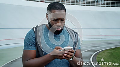 Man reading bad news on mobile phone. Jogger using smartphone after workout Stock Photo