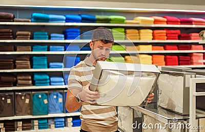 Man selecting bedclothes in shop Stock Photo