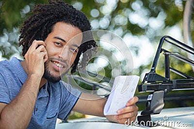 man reading instruction for instaling bar on roof car Stock Photo