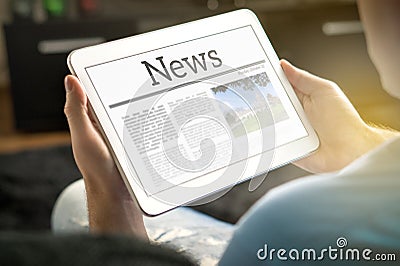 Man reading the news on tablet at home. Stock Photo