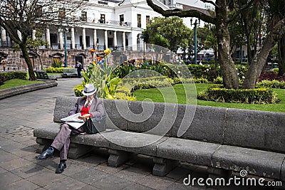 Man reading a newspaper in a bench in a park in the Independence Square at the city of Quito, in Ecuador Editorial Stock Photo