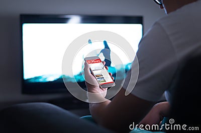 Man reading online news on smartphone at home. Stock Photo