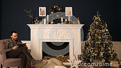 Man reads the book in the Christmas room. Stock Photo