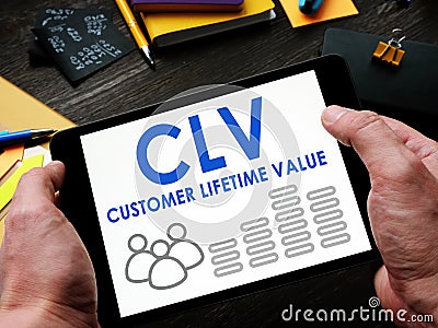 Man reads a Customer Lifetime Value CLV report on a tablet. Stock Photo