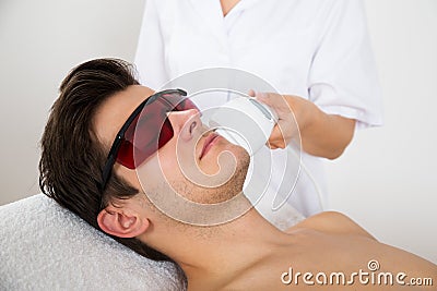 Man Receiving Laser Hair Removal Treatment Stock Photo