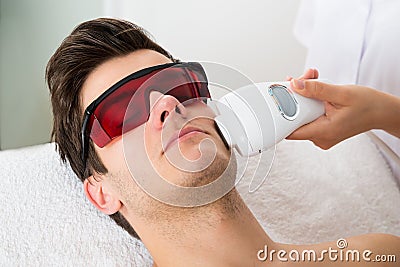 Man Receiving Laser Hair Removal Treatment Stock Photo