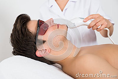 Man Receiving Laser Hair Removal Treatment Stock Photo