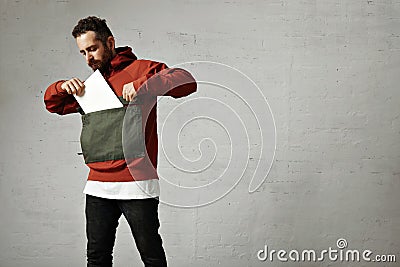 Man in red anorak with white sheet of paper Stock Photo