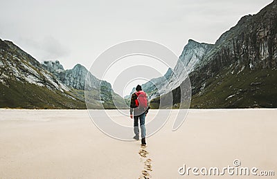 Man with red backpack walking alone Stock Photo