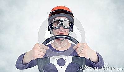 Man in red helmet and goggles with steering wheel. car driver concept Stock Photo
