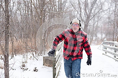 Man in red jacket running in the fresh snow Stock Photo