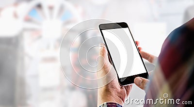 The man in a red plaid shirt stands holding a smartphone blank screen on the background of taking a studio line item. Stock Photo