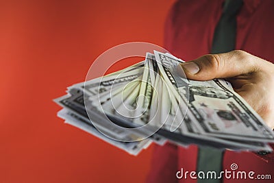 man in red shirt with a holding a pack of bills in his hand on a red background Stock Photo