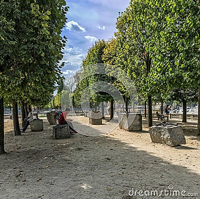 Man in red shirt rests on stone near Louise Bourgeois sculptures in the Tuileries, Paris, France Editorial Stock Photo