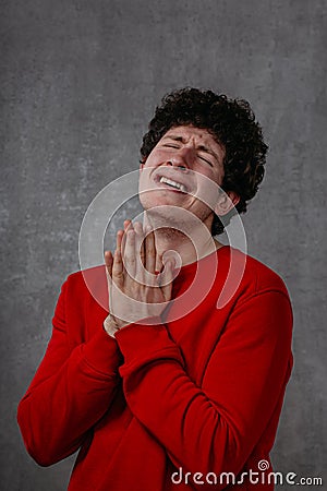The man in the red sweater is very unhappy, conveys the emotion of grief and despair Stock Photo