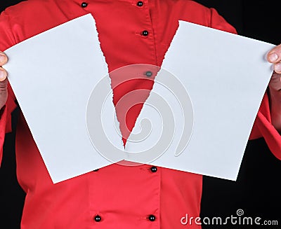 Man in a red uniform holds a white sheet of paper torn in half Stock Photo