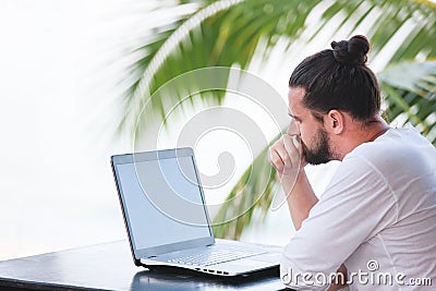 Man relaxing on the beach with laptop, freelancer workplace, dream job Stock Photo