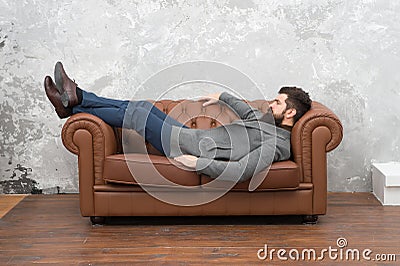 Man relaxing on luxurious leather couch, furniture store concept Stock Photo