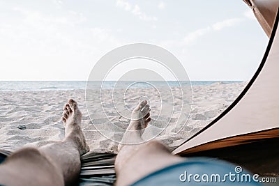 Man relaxing in a tent in front of sea. Stock Photo