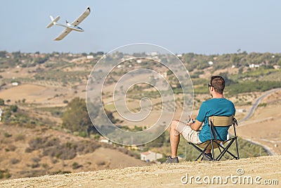 Man with remote control plane flying in air Stock Photo