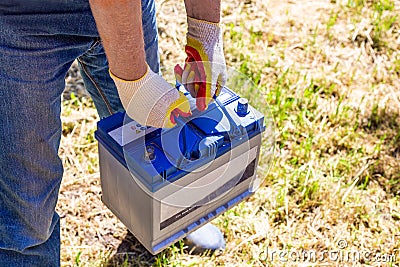 The man removed the car battery from the car in order to have it repaired or replaced. Transport service Stock Photo