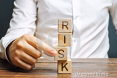 Man removes blocks with the word Risk. The concept of reducing possible risks. Insurance, stability support. Legal protection of Stock Photo