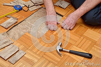Man Removing Damaged Parquet in Apartment Stock Photo