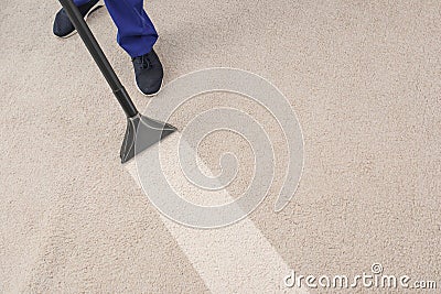 Man removing dirt from carpet with professional vacuum cleaner in room Stock Photo