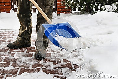 Man removing snow from the sidewalk after snowstorm Stock Photo