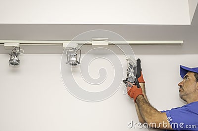 Man removing a track light Stock Photo