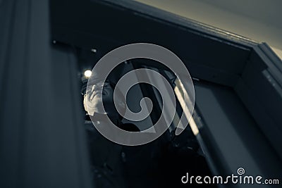 Man repairing an elevator at night inside a shaft of a high-rise building, front and background blurred with bokeh effect Stock Photo