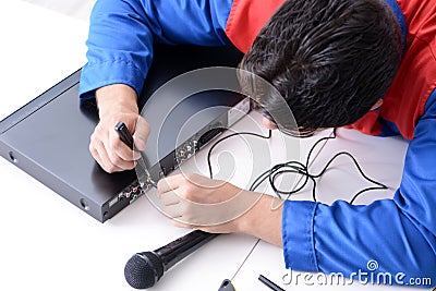 The man repairman repairing dvd player at service center Stock Photo