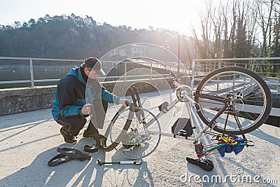 Man repairs a bicycle with flat tire. Concept of unforeseen Stock Photo