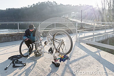 Man repairs a bicycle with flat tire. Concept of unforeseen Stock Photo