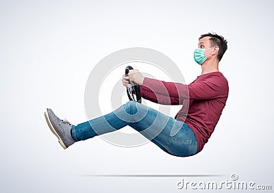 Man in respiratory mask drives a car while holding a steering wheel. Difficult period travel concept. Stock Photo