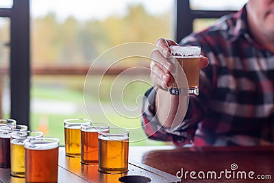 Man at a restaurant sampling beer from a beer flight Stock Photo