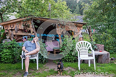 Man resting on a chair in his yard Stock Photo