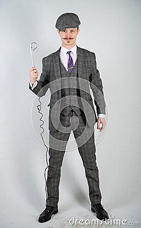 Man in a retro suit stands and holds a vintage water boiler on a white Studio background alone Stock Photo